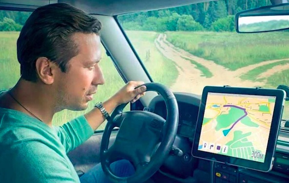 мужчина водитель смотрит на навигатор в автомобиле